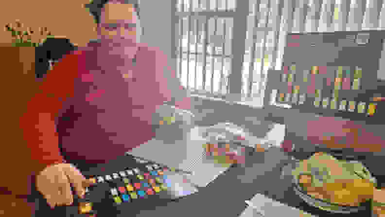 A man opening the Lego Braille Bricks packaging.