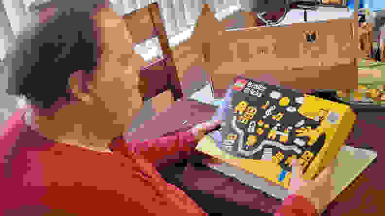A man holding the LEGO Braille Bricks box.