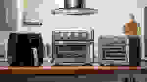 Basket Philips air fryer and Cuisinart air fryer toaster ovens lined up on a kitchen counter.