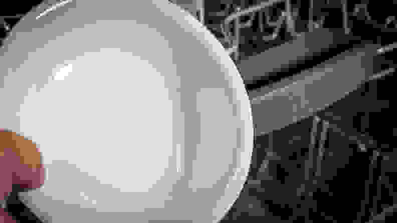 A close-up of a dish, which is spotless, in front of the Bosch 100 Series dishwasher.