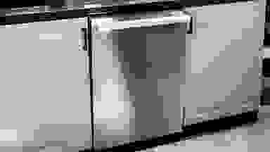 A close-up shot of a stainless steel dishwasher installed into a kitchen cabinet.