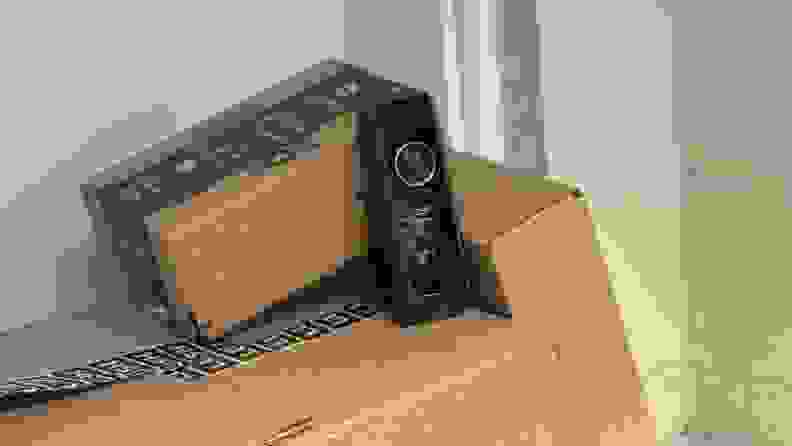 The Eufy Video Doorbell Dual, the best video doorbell camera for package deliveries, sits on top of several brown package boxes.