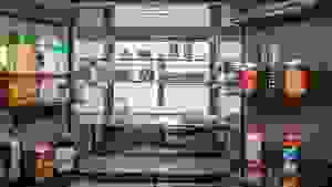 A close-up of the fridge's interior, fully stocked with food and lit by its interior LED back panel.