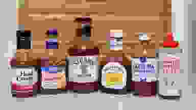 Six different bottles of BBQ sauce side-by-side.
