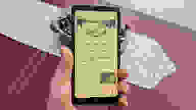 An Onyx Palma e-reader being held in a living room.