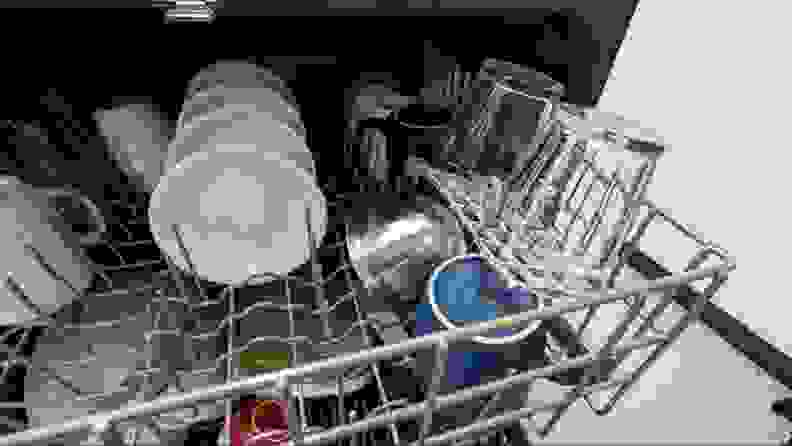 A close-up of the upper rack which has a small shelf folded down over a mug and bowl stowed below. Two glasses are sitting on the shelf.