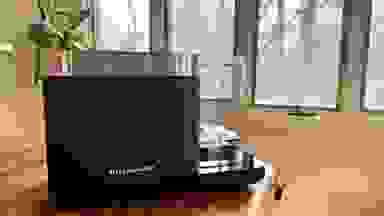 Navy blue KitchenAid Grain and Rice Cooker sitting on wooden countertop in front windows.