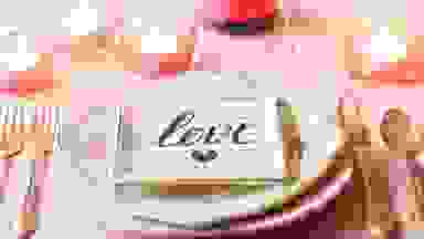 A table set with romantic decorations for a Valentine's Day dinner.