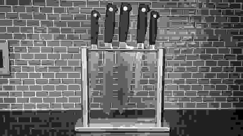 The best budget knife set in a thin glass case against  a subway tile kitchen backsplash.