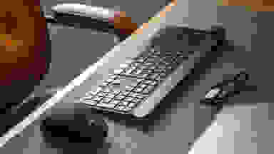 A picture of a wireless keyboard and mouse on a desk mat