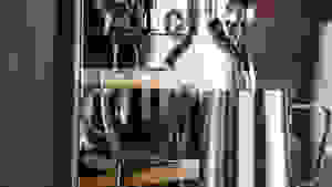 A close-up photo of the Breville Nespresso Creatista brewing an espresso shot and frothing milk.