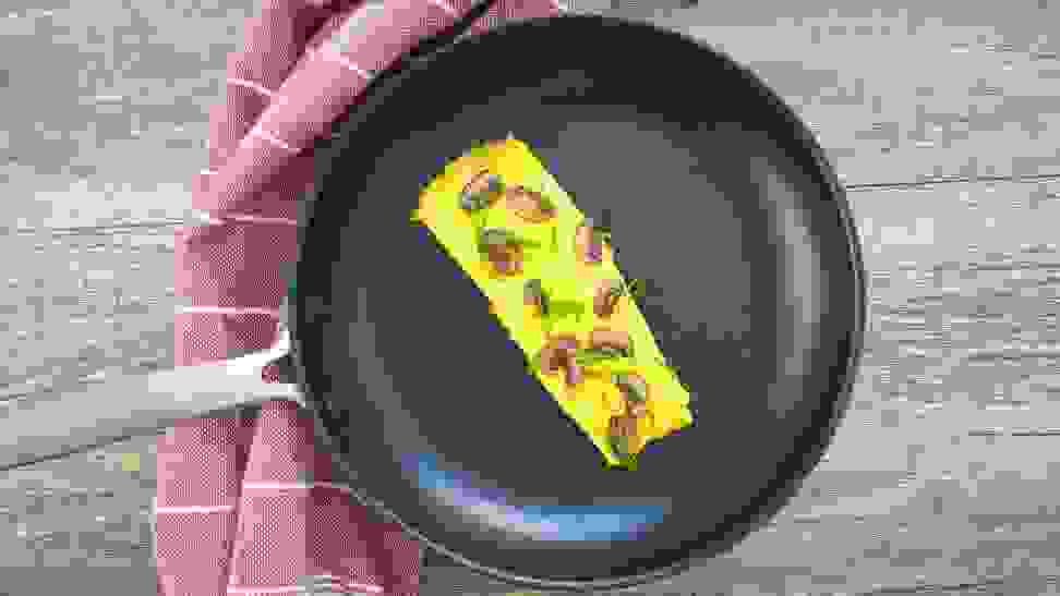 Eggs frying in an OXO nonstick pan on a stovetop.