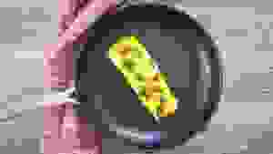 Eggs frying in an OXO nonstick pan on a stovetop.