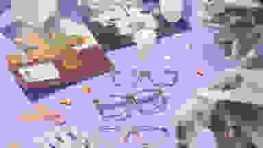 Halloween-themed eyewear on purple background with skeleton