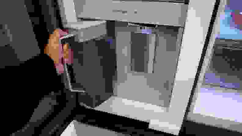 Person using hand to remove the auto-fill water pitcher from the Beverage Center on the Samsung Bespoke RF23DB9700QL Refrigerator.