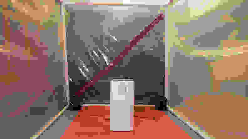 An air purifier stands in front of an air tight room.