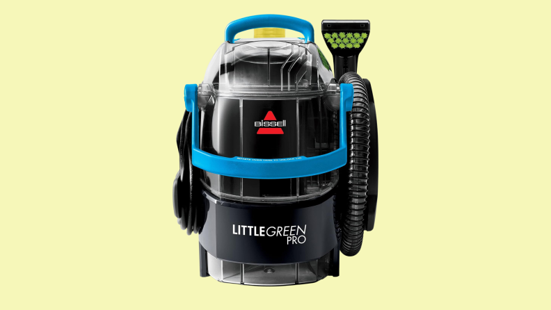 A small Bissell carpet cleaner sits on a yellow background.
