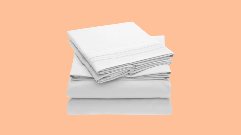 A light colored stack of twin XL bed sheets float above an empty peach background.