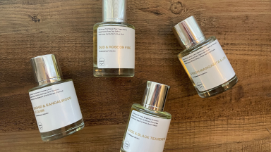 Four bottles of perfume on a wooden surface.