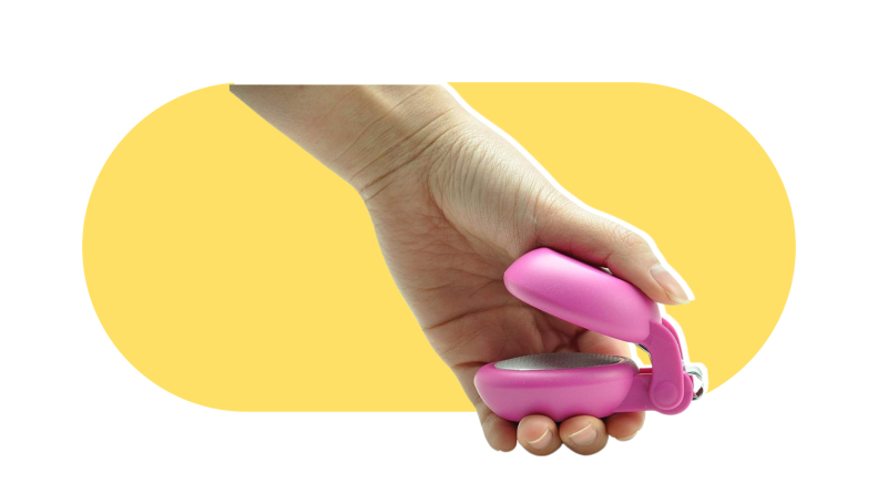 Pink Harac nail nail clippers on a yellow and white background. A user squeezes their large, round handle.