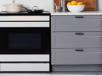 The Samsung Bespoke NSI6DB990012AA Induction Range between grey cabinets in a kitchen.