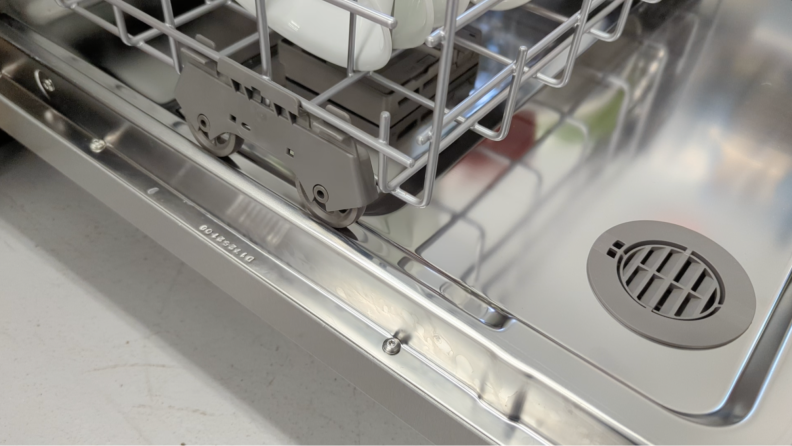 A close-up of the lower rack getting slowly pulled out and easily jumping off its track.