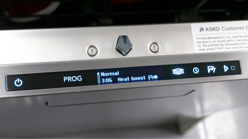 The Asko dishwasher’s interface is shown on the top of its door, with the Heat Boost cycle selected.