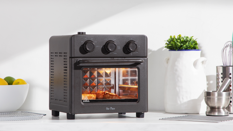 Our Place Wonder Oven with salmon cooking inside on marble surface